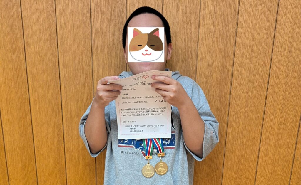 スペシャルオリンピックスの賞状を手にするJ君