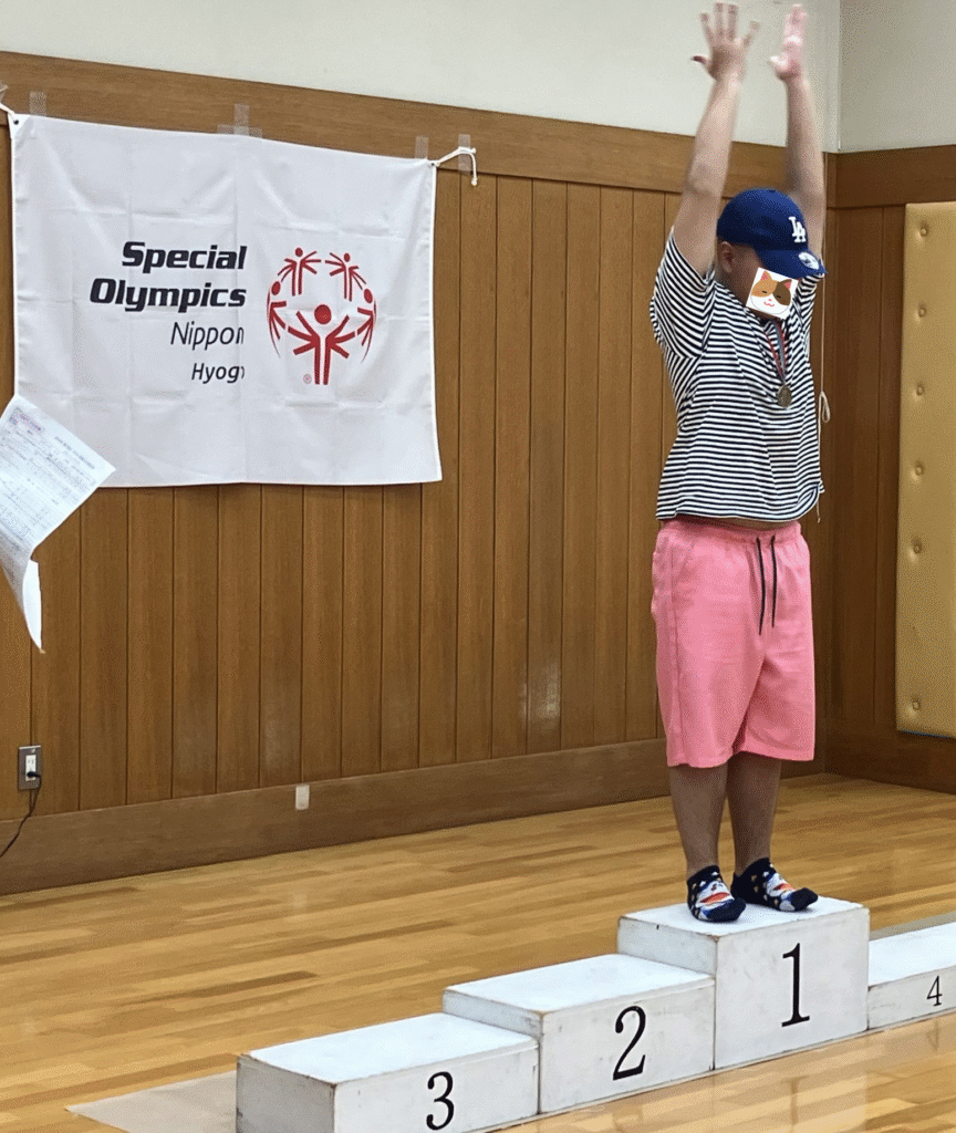 表彰台で万歳をするJ君